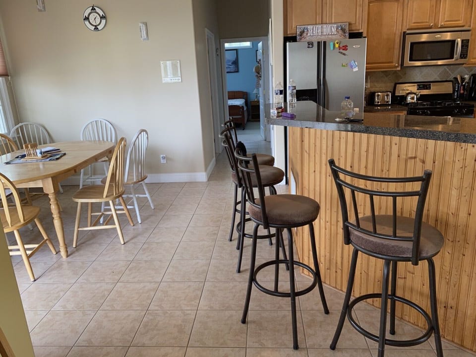 Open kitchen with counter seating and kitchen table with additional seating 