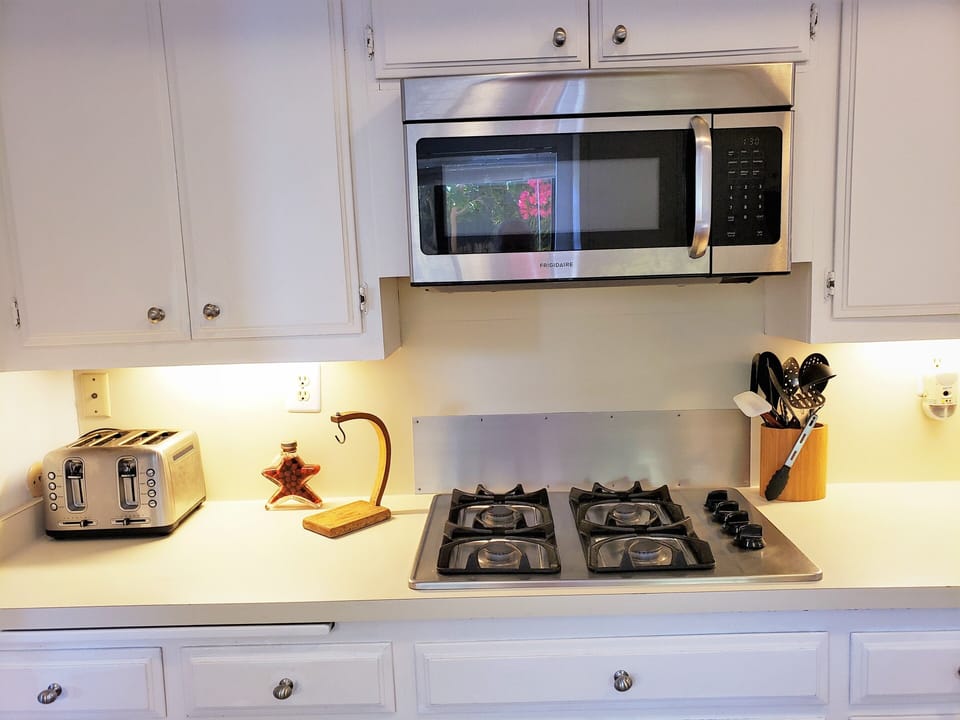 Microwave over gas stovetop, toaster,lots of utensils, pots, pans provided