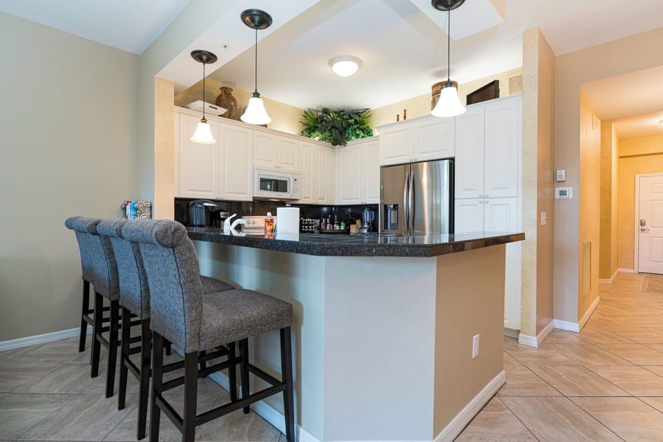 Modern kitchen with new appliances and dining counter.