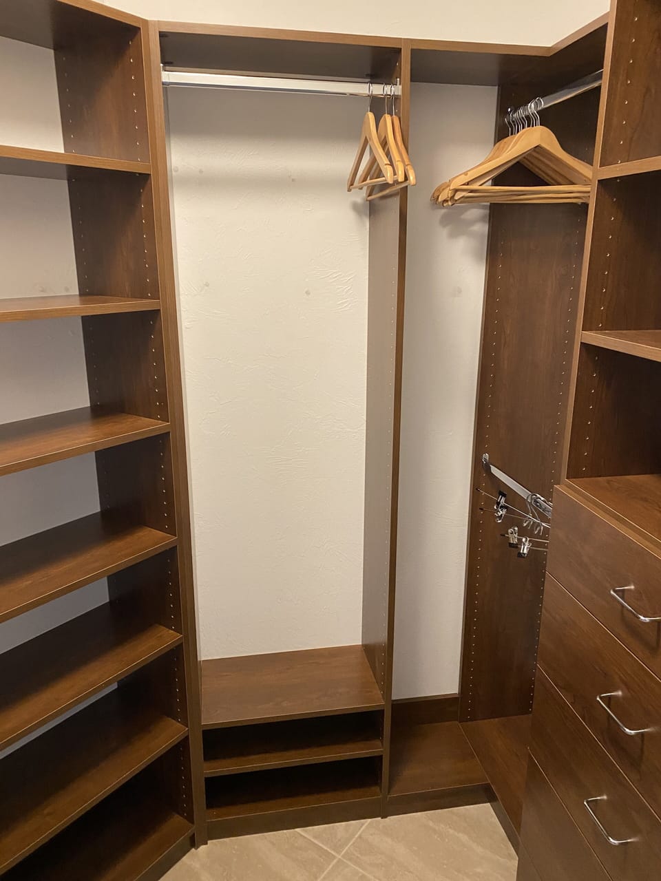 Master Bathroom walk-in Closet with shelves, drawers, and robes. 