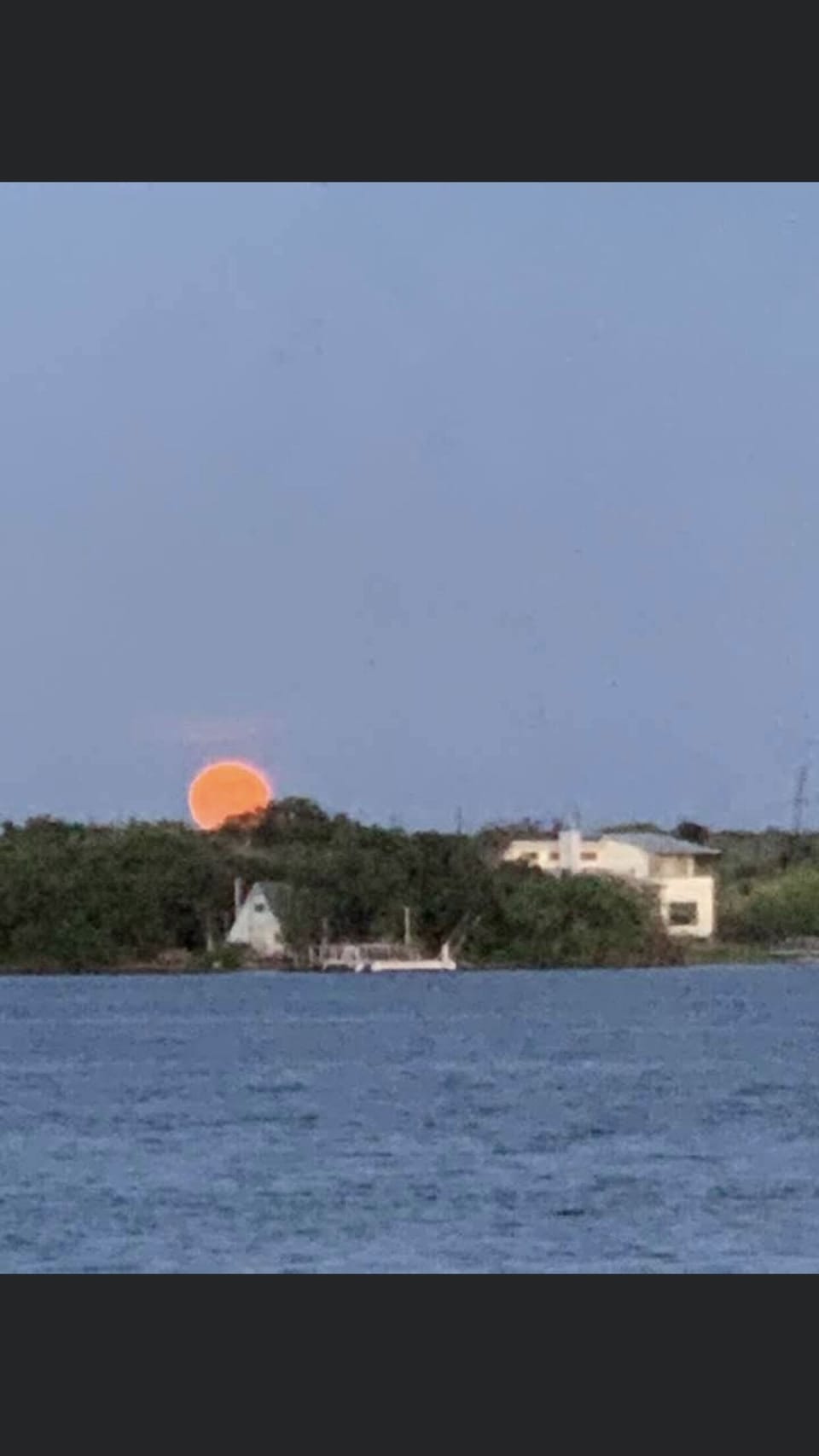 The moon waking up across the lake
