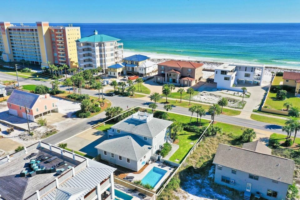 Elevated neighborhood view w/ rooftops leading toward the shoreline.