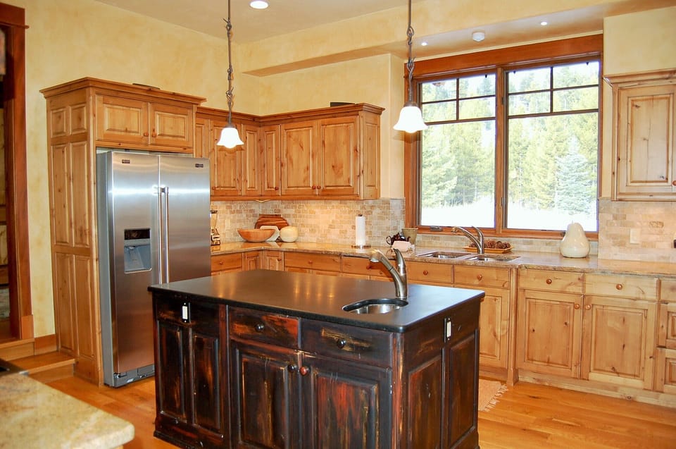 Gourmet kitchen stocked with glasses, dishes, pots and pans and accessories. 