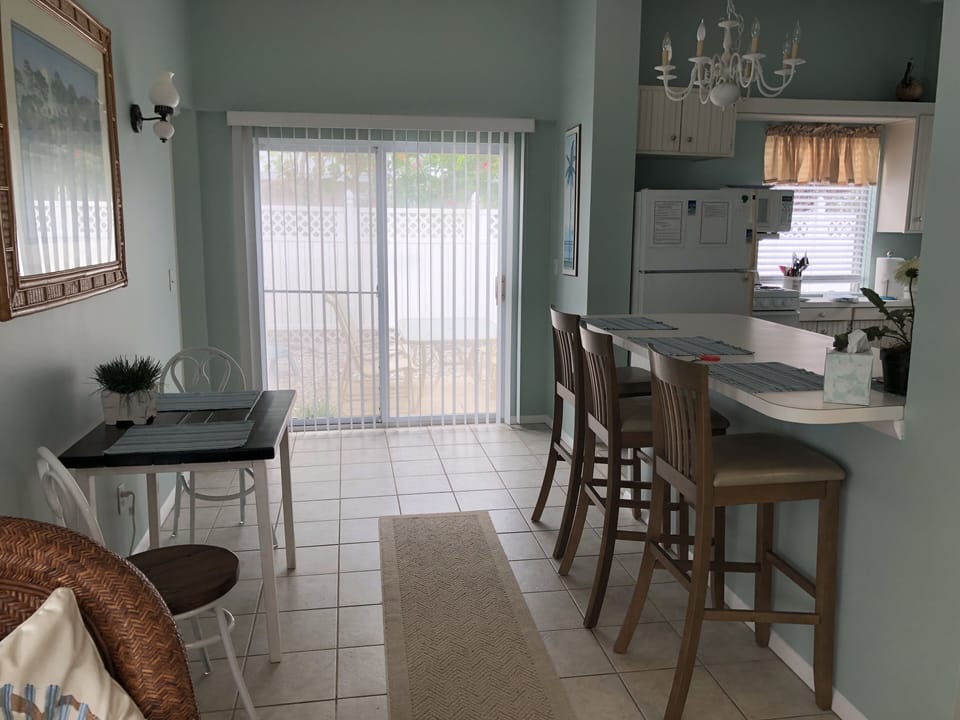 The sliding glass door leads to a small patio with a table and 4 chairs