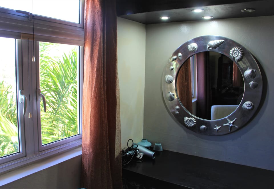 Hand embellished silver mirror and well-lit dressing table.