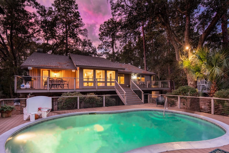 Back of house with pool deck and 2 upper seating areas