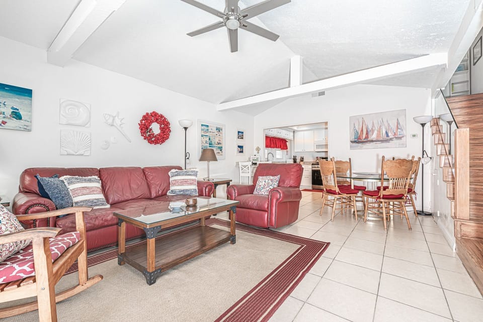 The main living area includes dining table with seating for four, sofa and recliner, cable TV, gas log fireplace, and sliding glass door out to the private rear patio.
                
