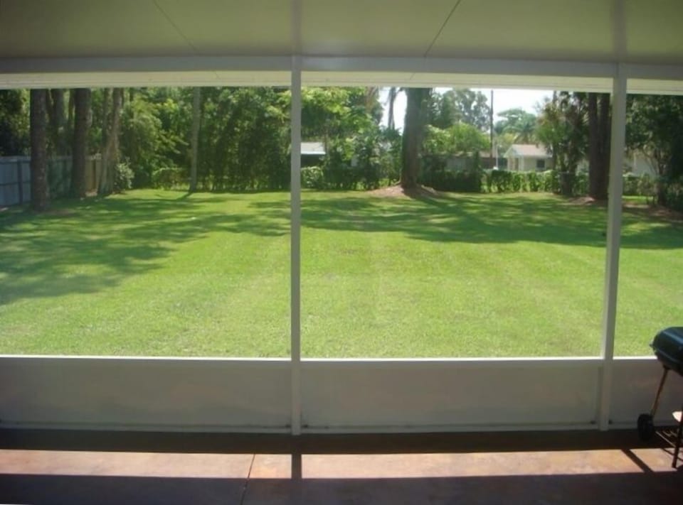 View of fully fenced back yard from 12 x 40 foot screened lanai