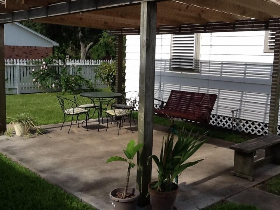 Lattice covered patio area with table and seating for 4