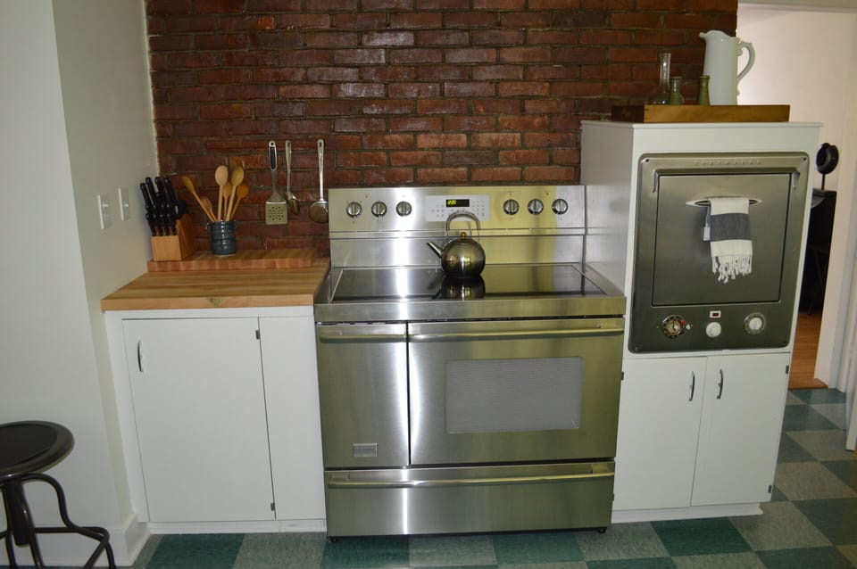 Pro Range w/sleek cooktop and double-oven, chopping block, stainless cookware.
