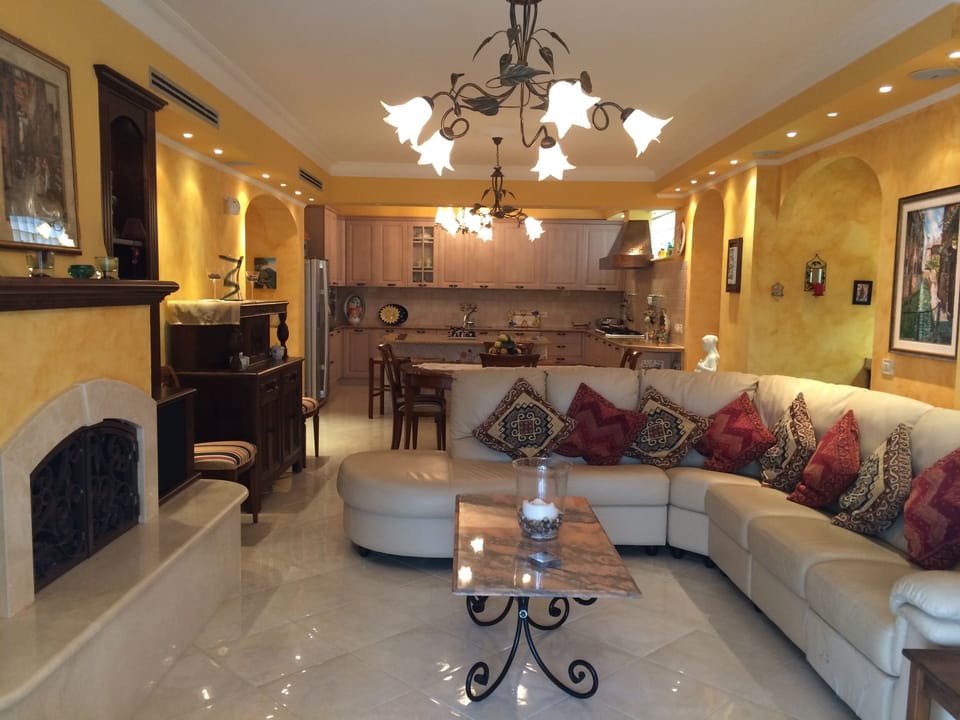 Living room to kitchen with gas fireplace and bar thru right archway.