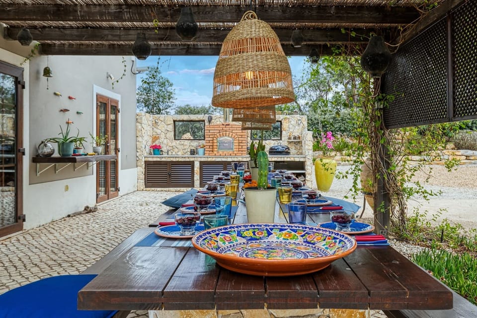 Outdoor seating area leading off kitchen with pizza oven, gas and charcoal BBQs.
