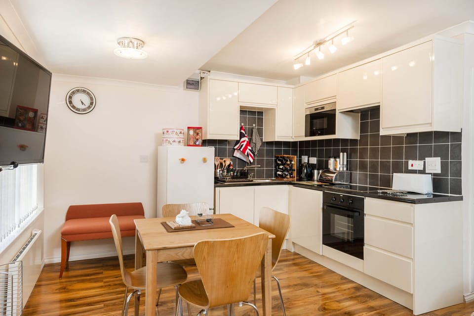 Another view of the kitchen, showing extendable dining table and luggage rack.
