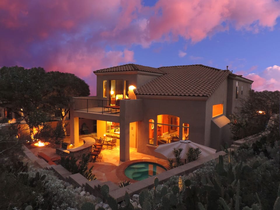 Backyard oasis with hot tub, fire pit, bar, and BBQ overlooking the desert.