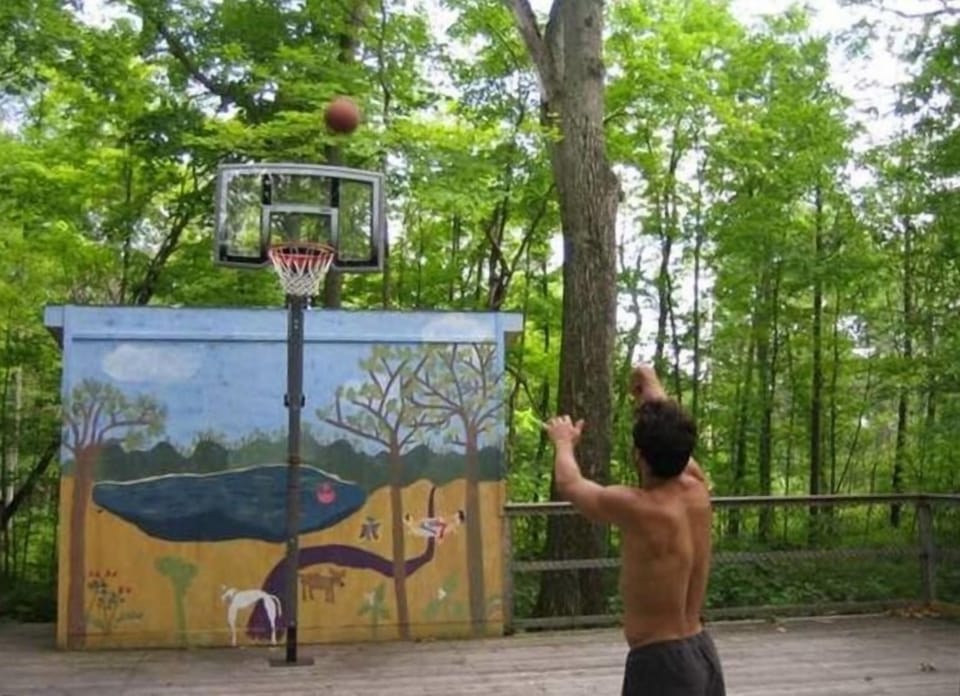 half size basketball court, with mural, lit at night