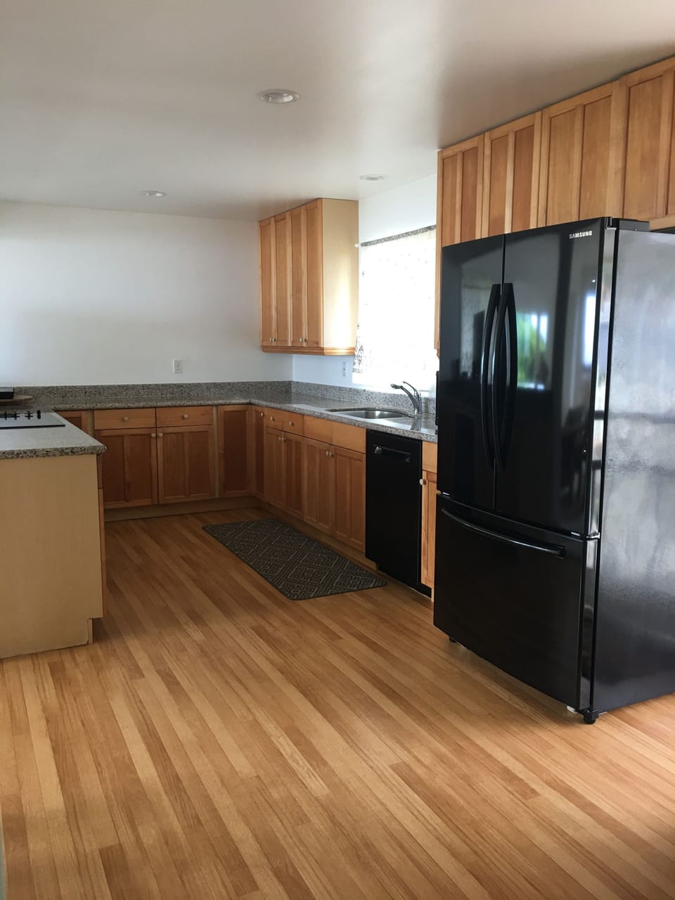 Kitchen with refrigerator, cooktop, convection oven, dishwasher, & microwave.