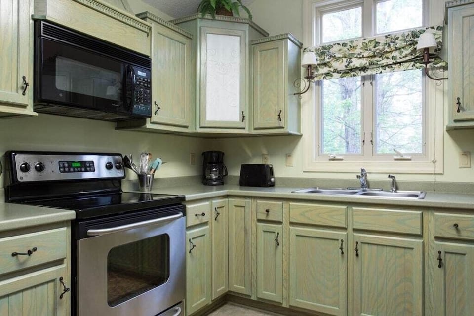 There is a smooth-top electric range and microwave above it. The dishwasher is on the opposite side of the U-shaped kitchen.