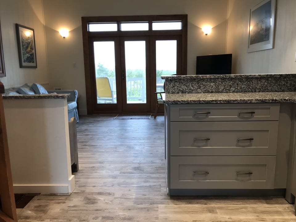 View of living room and deck looking onto beach dunes from the kitchen