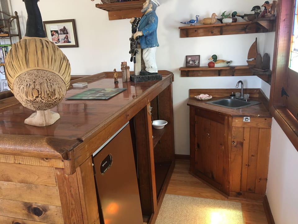Wet bar with sink and refrigerator on left side of great room