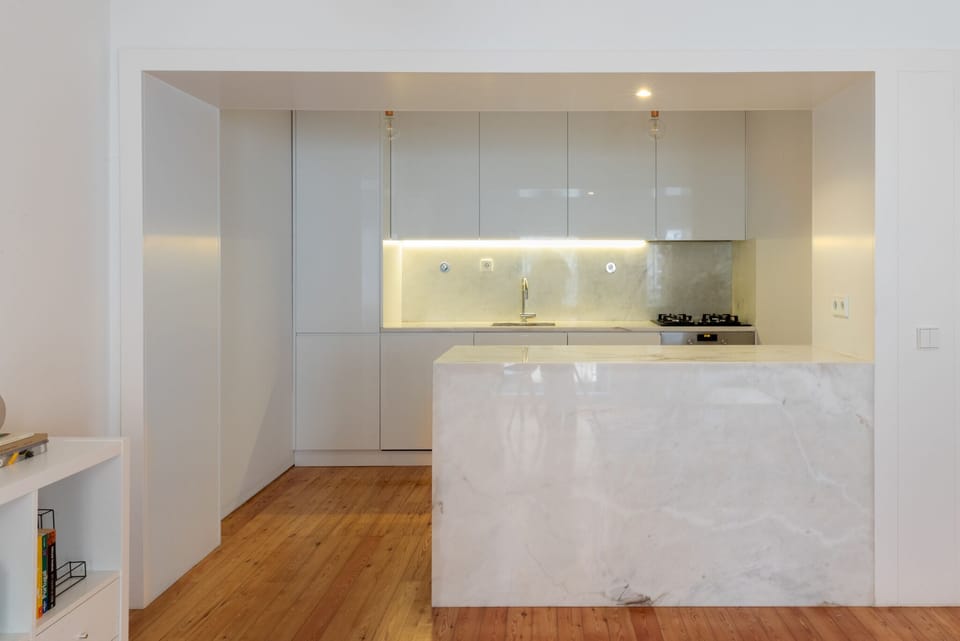 The kitchen and the balcony to the living room with an elegant Estremoz marble