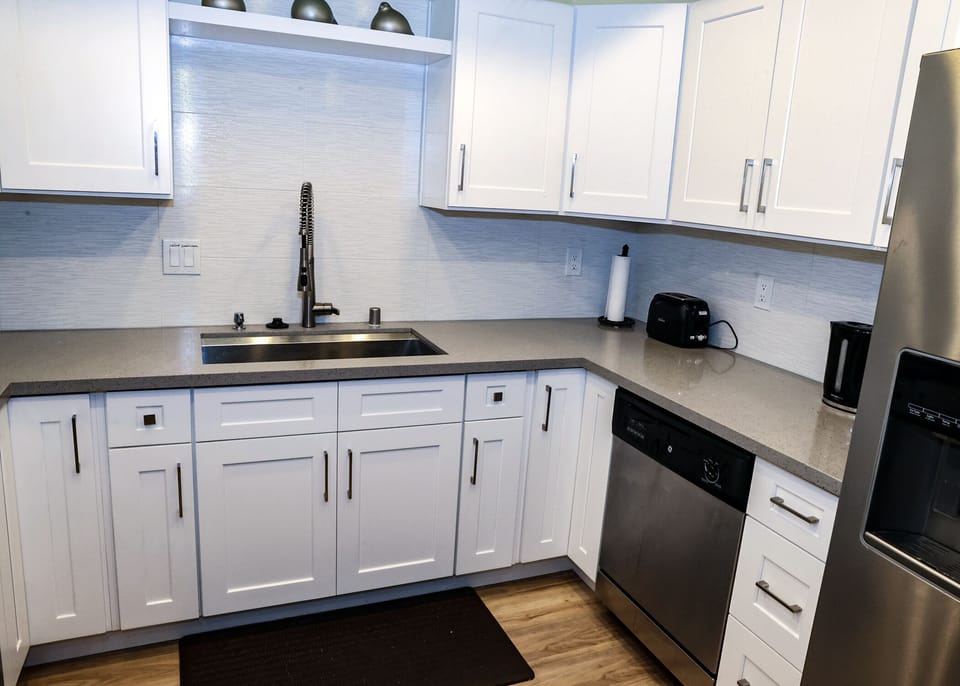Sink and Quartz counter and dishwasher and fridge.  