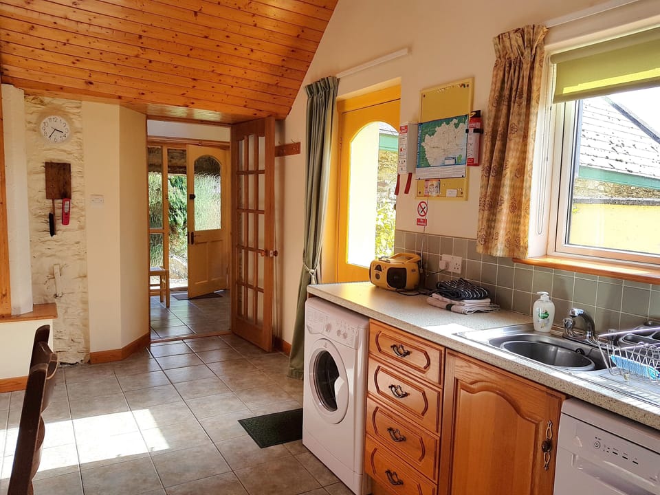 Horseshoe kitchen with door to hallway and door on right to private patio