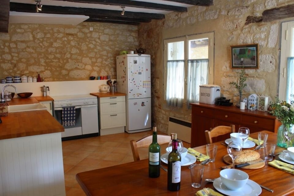Exposed stone, oak beams & large wooden table make kitchen the heart of the home