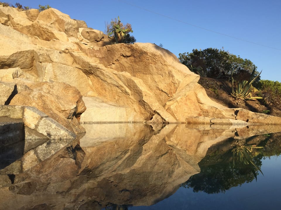 The stunning infinity pool, carved off the granite, becomes a mirror at sunset