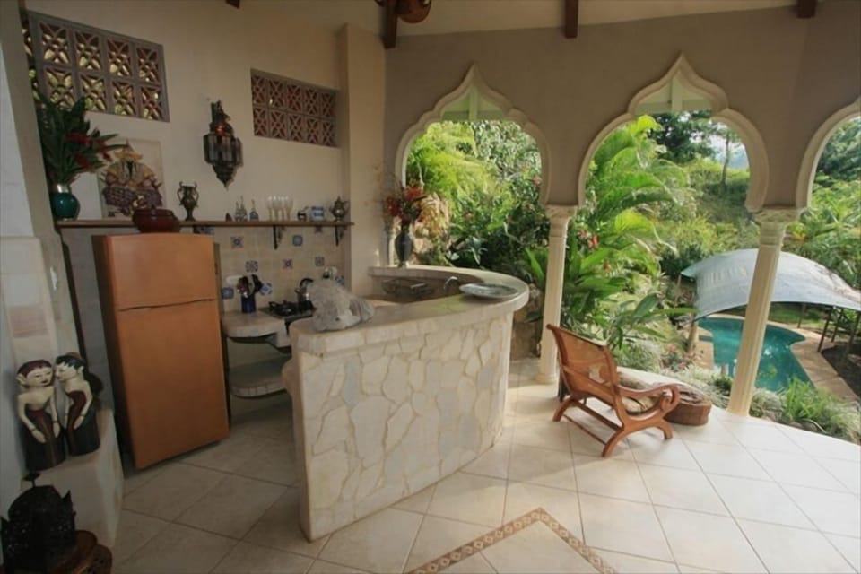 enjoy cooking and dining as you overlook your pool and lush gardens