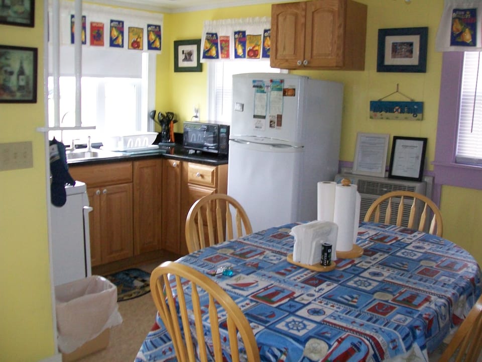 Another picture of the kitchen with stove refrigerator and kitchen table for 4.