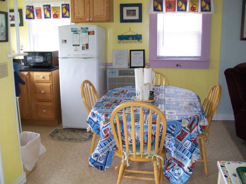View of the kitchen area with table and chairs for four for dining.
