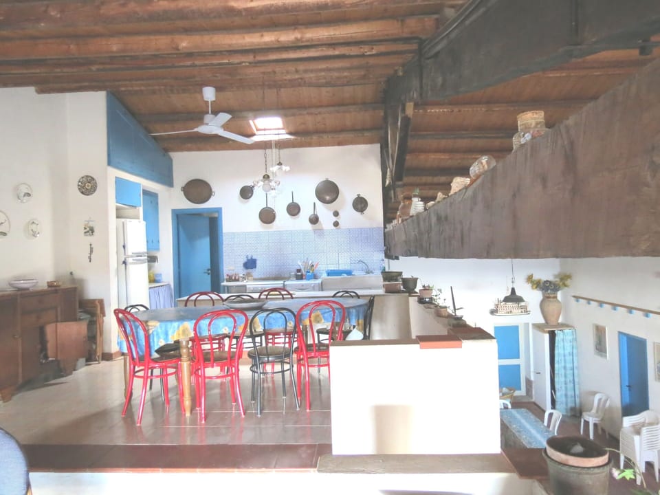 Dining room with roof fan and kitchen behind