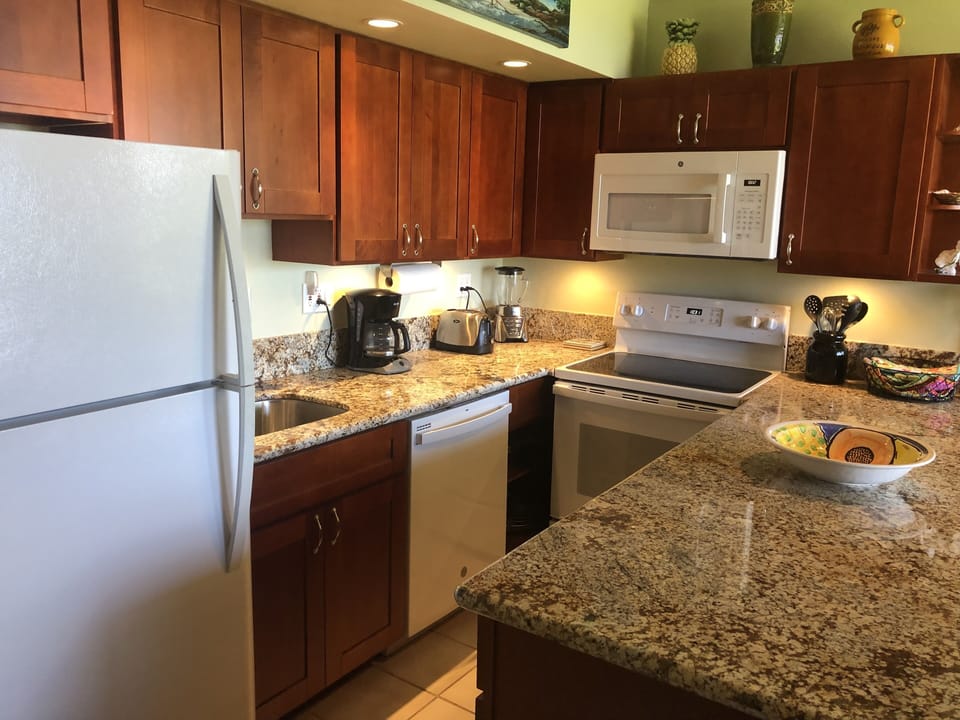 New kitchen with well stocked cherry wood cabinets.