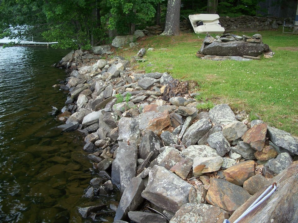 THE ROCK BOUND WATERFRONT. THERE IS NO BEACH, INSTEAD A DOCK TO JUMP IN 