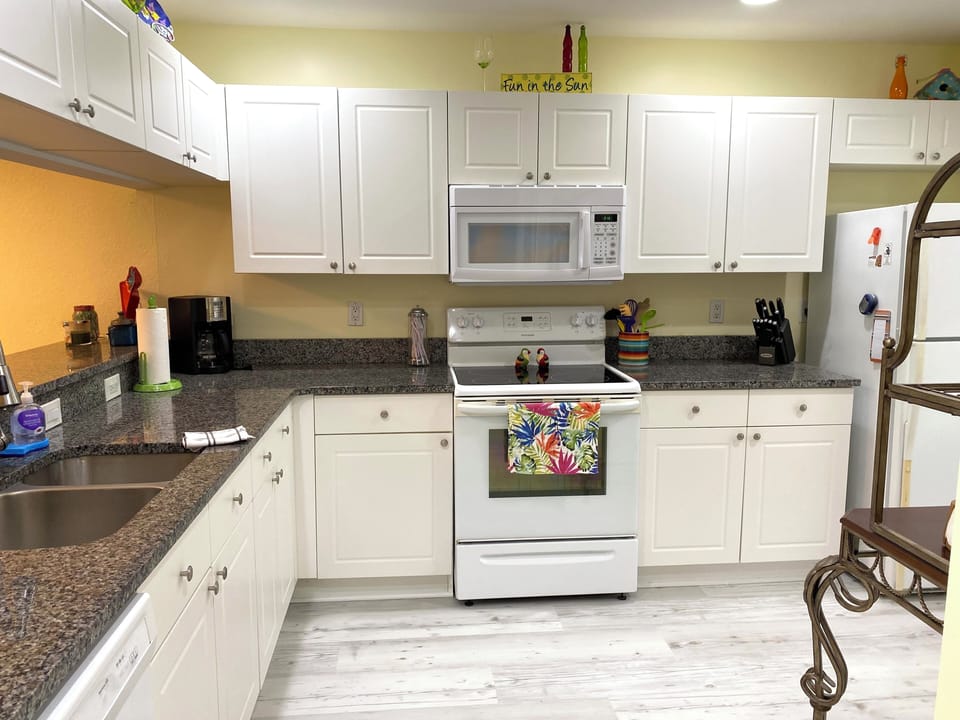 large fully stocked kitchen with granite counter tops