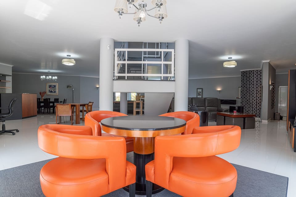 Modern lounge with curved orange leather seating — Villa Atlantica, luxury holiday villa in Grândola