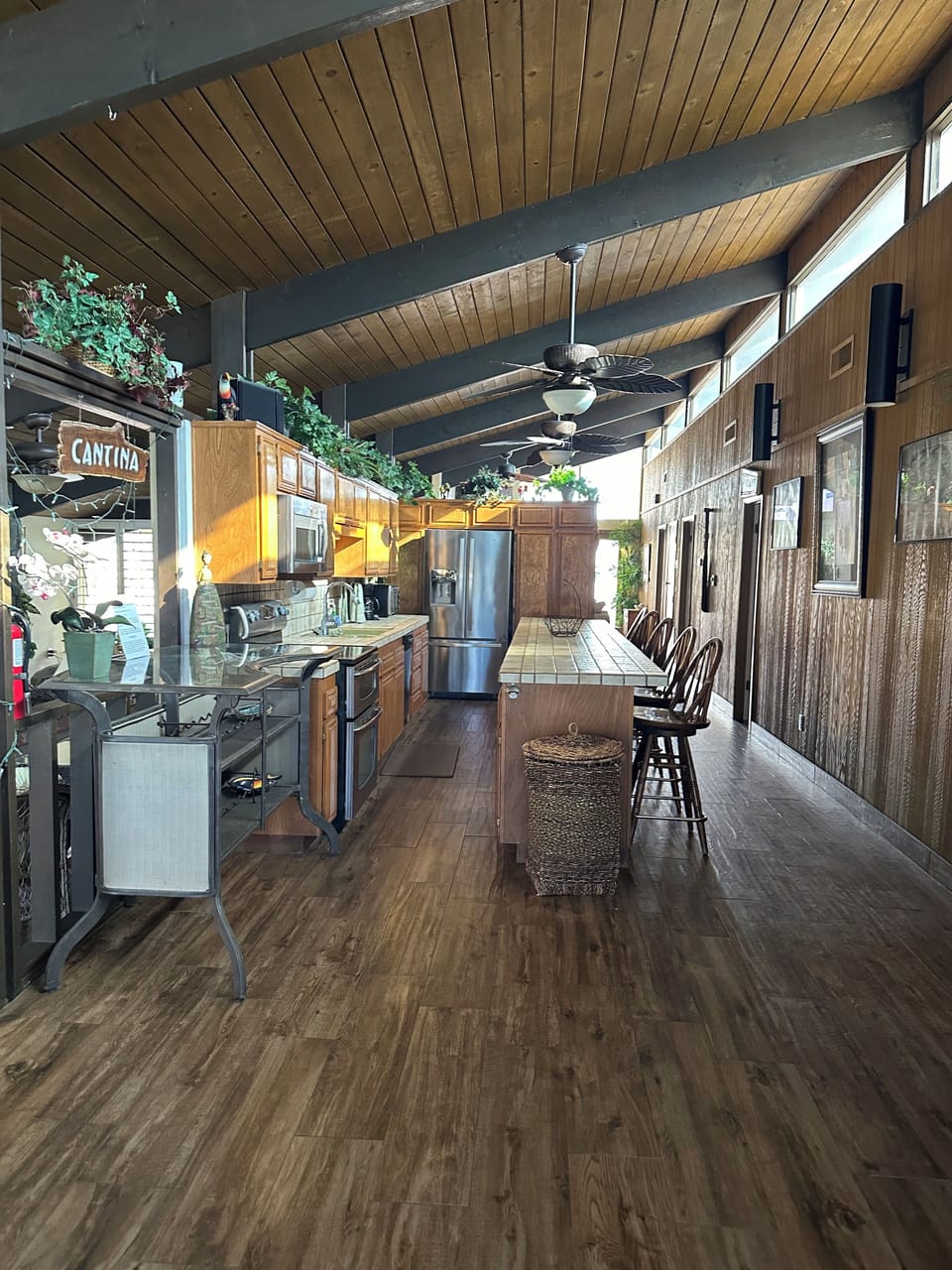 Kitchen with living room and front door behind refrigerator area