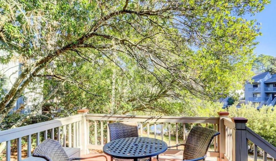 Sip morning coffee on the breezy balcony under leafy shade.