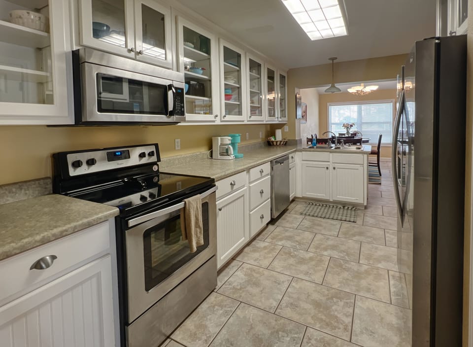 Large galley kitchen with whimsical coastal dishes and plenty of amenities. 