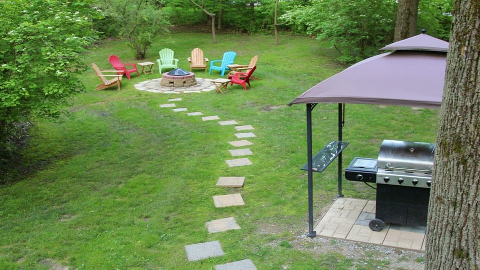 Fire pit with plenty of seating. Barbecue in forefront.