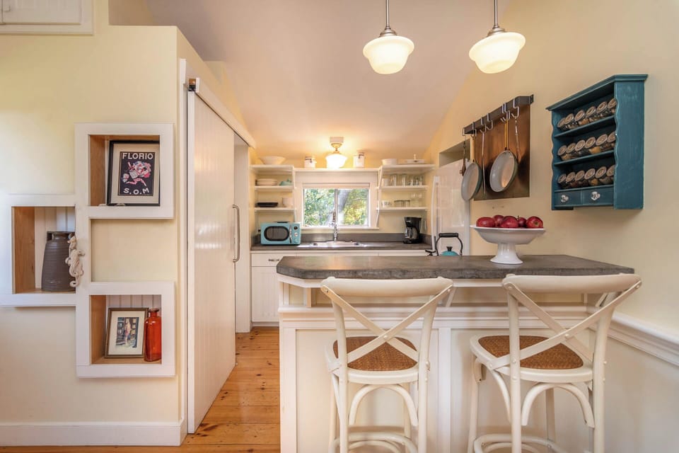 Sweet kitchen with bar, barn doors into full bath.