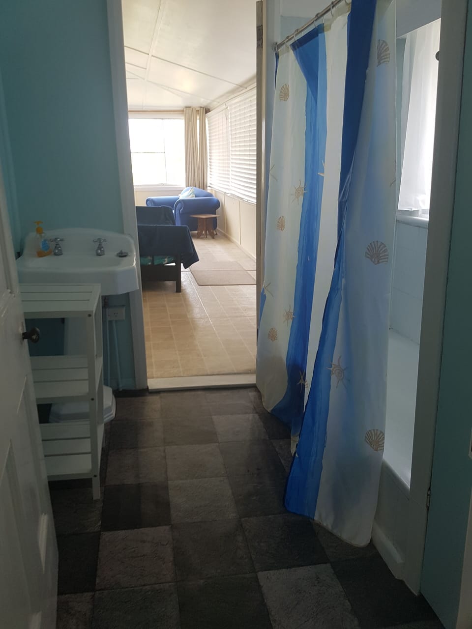 Bathroom with shower over bath looking toward sunroom from laundry with separate