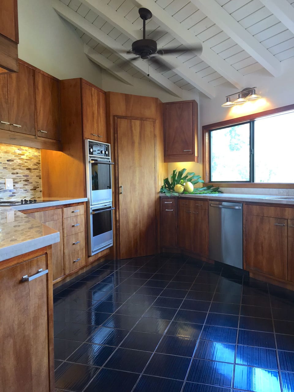 Chef's kitchen featuring koa cabinets, walk-in pantry and granite counter