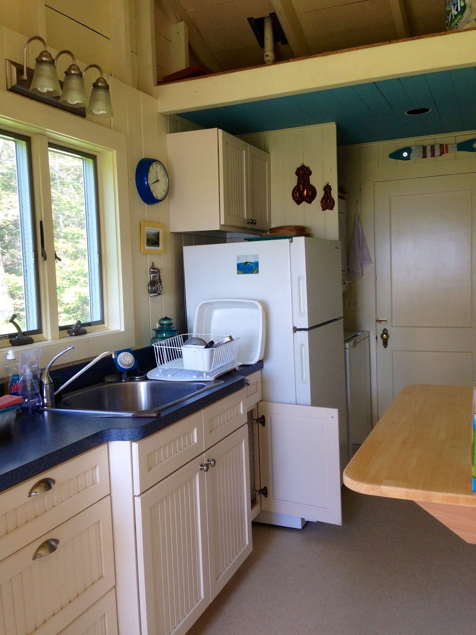 Galley kitchen with vaulted ceiling has views to waterfront and side yard.