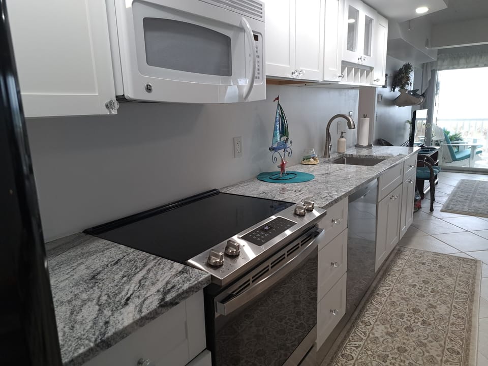 microwave, stove, oven, dishwasher, large sink along with coffee/keurig, toaster