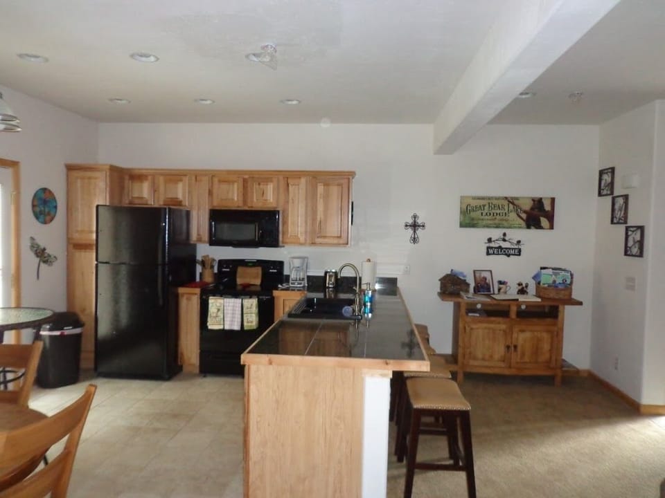 Kitchen features newer appliances, deep sink, and 3 barstools.