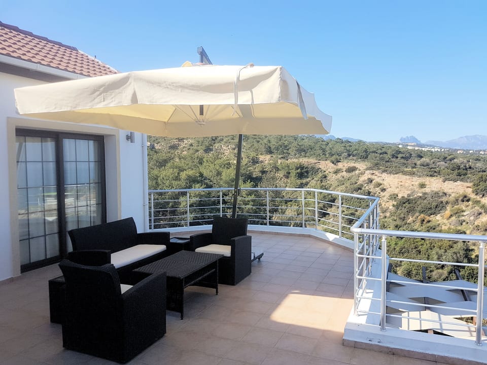 Terrace with lounging suite and substantial parasol