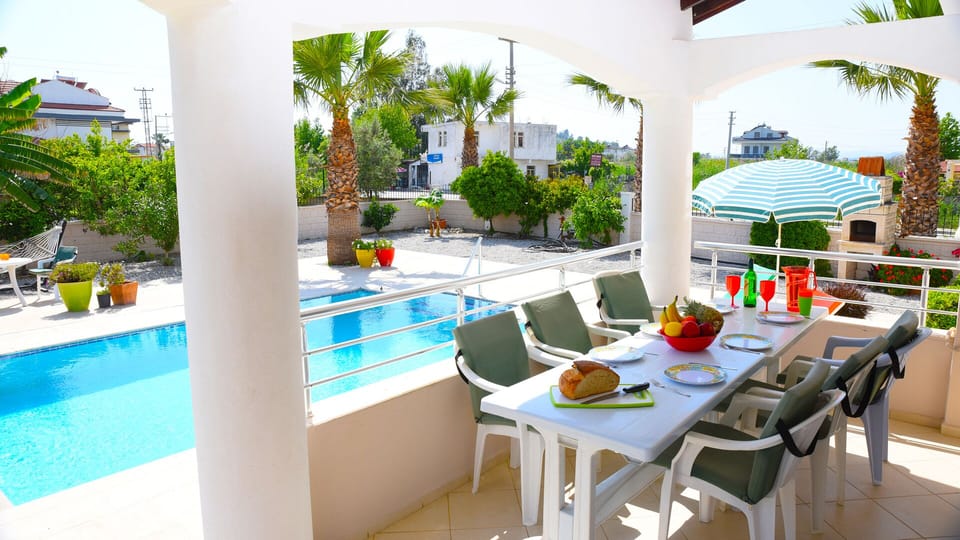 Shaded wrap-around balcony overlooking the pool — perfect for outdoor dining.