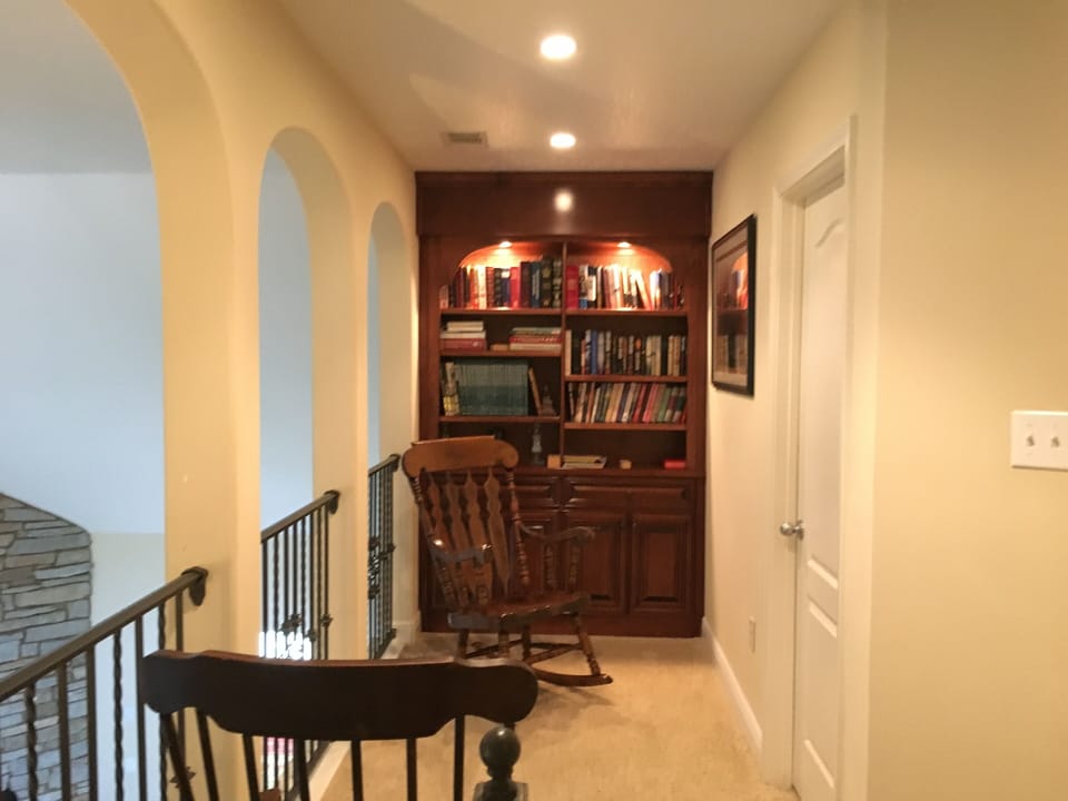 Second floor overlook with twin rocking chairs in front of bookcase unit. 