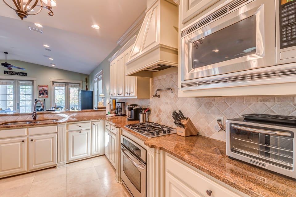 Elegant custom kitchen boasts granite counter tops & stainless steel appliances